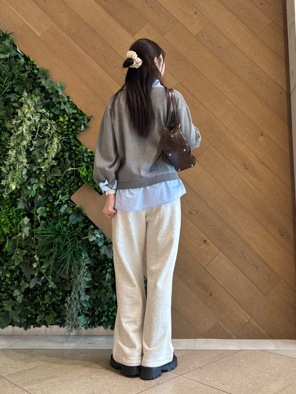 グレー系のニット/セーター、ホワイト系のスウェットパンツ、ブラウン系のボストンバッグを着用したレディースの春コーディネートの3枚目の写真