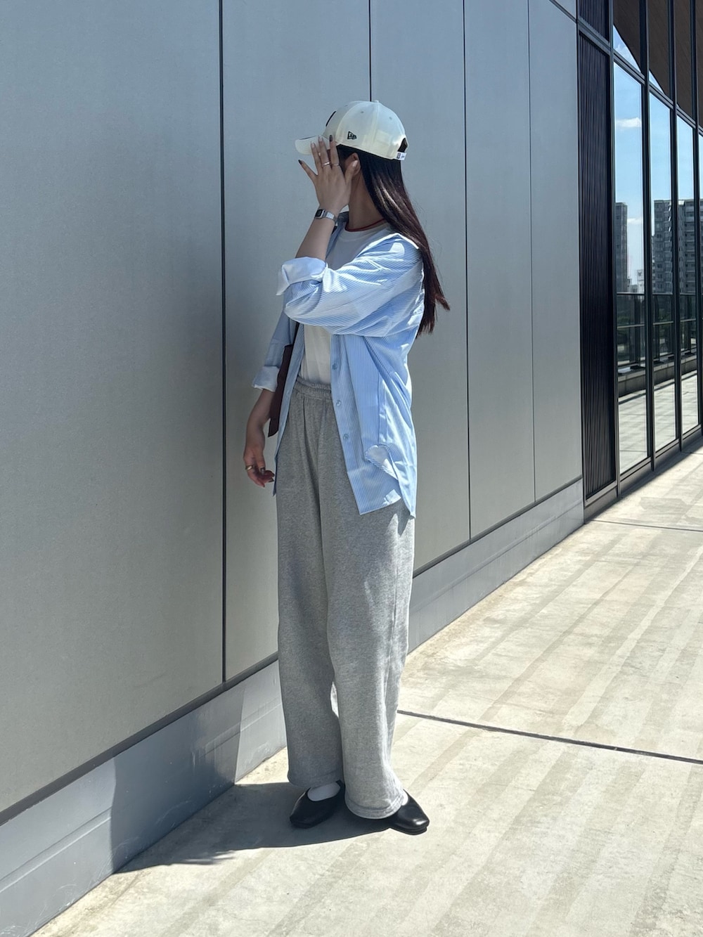 グレー系のスウェットパンツ、ホワイト系のTシャツ/カットソー、ブラウン系のトートバッグを着用したレディースの夏コーディネートの4枚目の写真