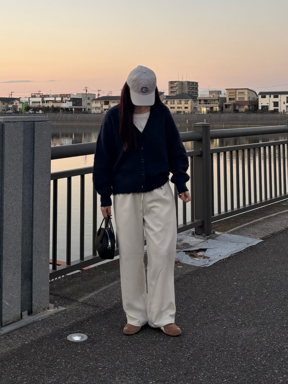 ブルー系のカーディガン/ボレロ、ブラック系のボストンバッグ、ホワイト系のその他パンツを着用したレディースの冬コーディネートの3枚目の写真