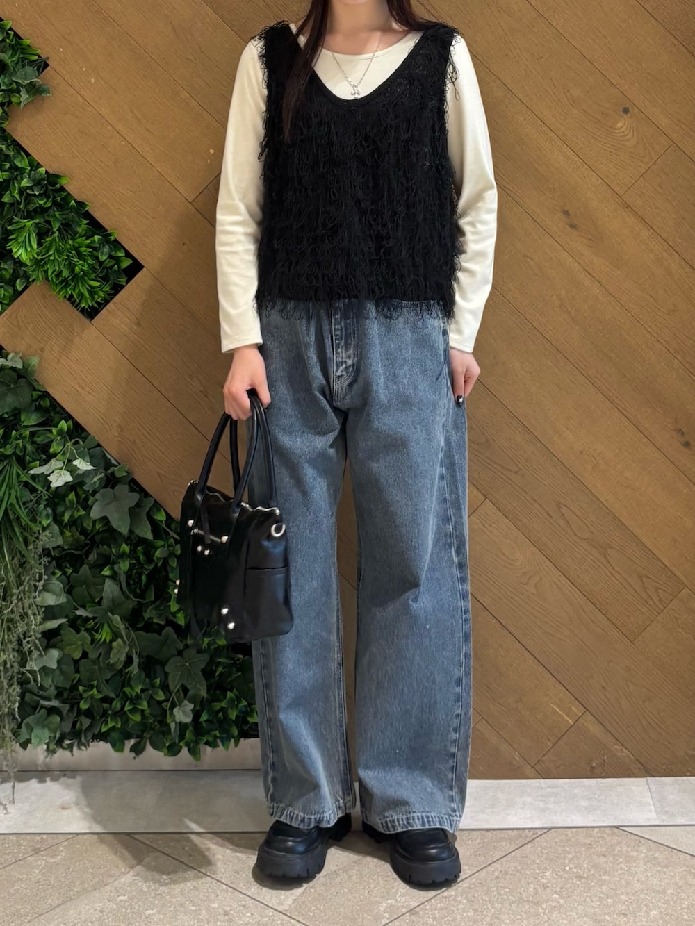 ホワイト系のTシャツ/カットソー、ブラック系のベスト、ブルー系のデニムパンツを着用したレディースの春コーディネートの4枚目の写真
