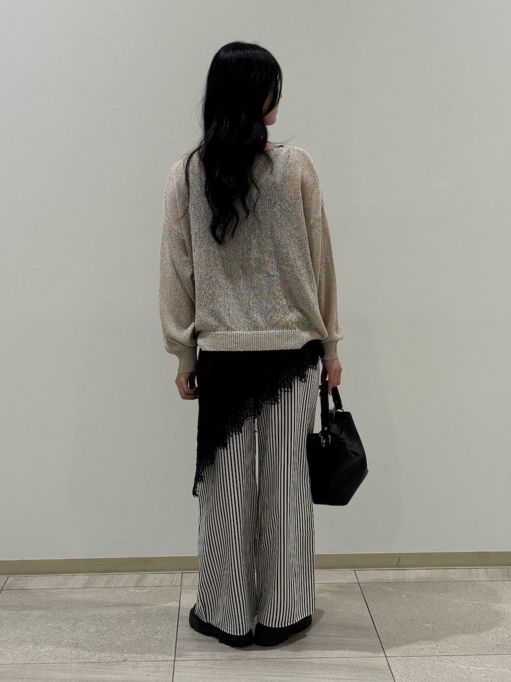 ベージュ系のニット/セーター、ブラック系のシャツ/ブラウス、ブルー系のその他パンツを着用したレディースの春コーディネートの3枚目の写真
