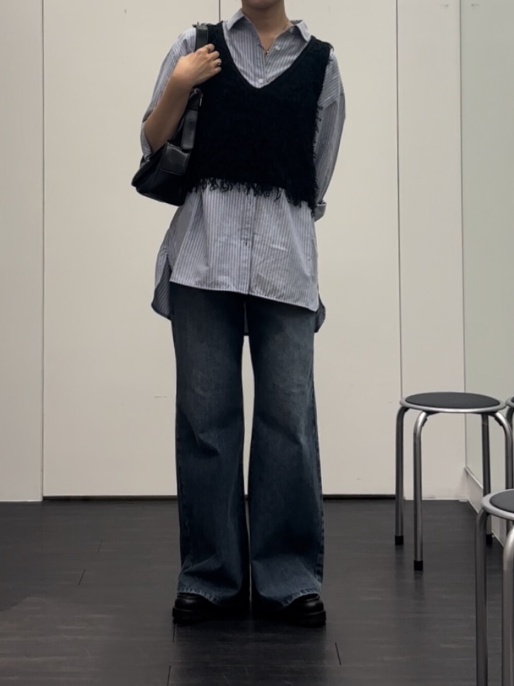 ブルー系のシャツ/ブラウス、ブラック系のベスト、ブラック系のショルダーバッグを着用したレディースの秋コーディネートの3枚目の写真