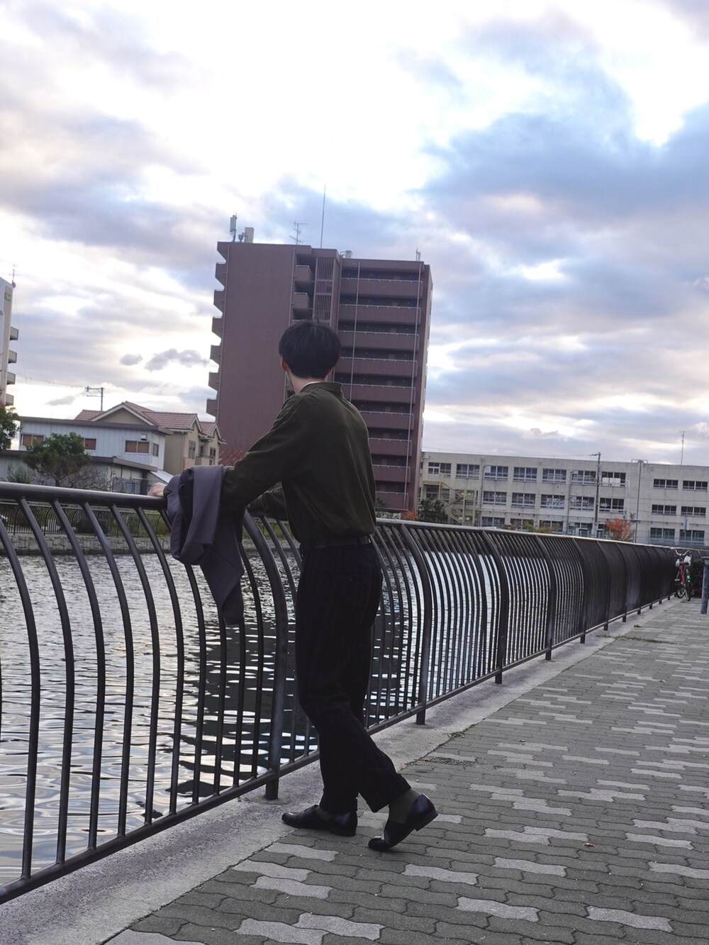 ブラック系のドレスシューズ、グレー系のテーラードジャケット、ホワイト系のトートバッグを着用したメンズの冬コーディネートの2枚目の写真