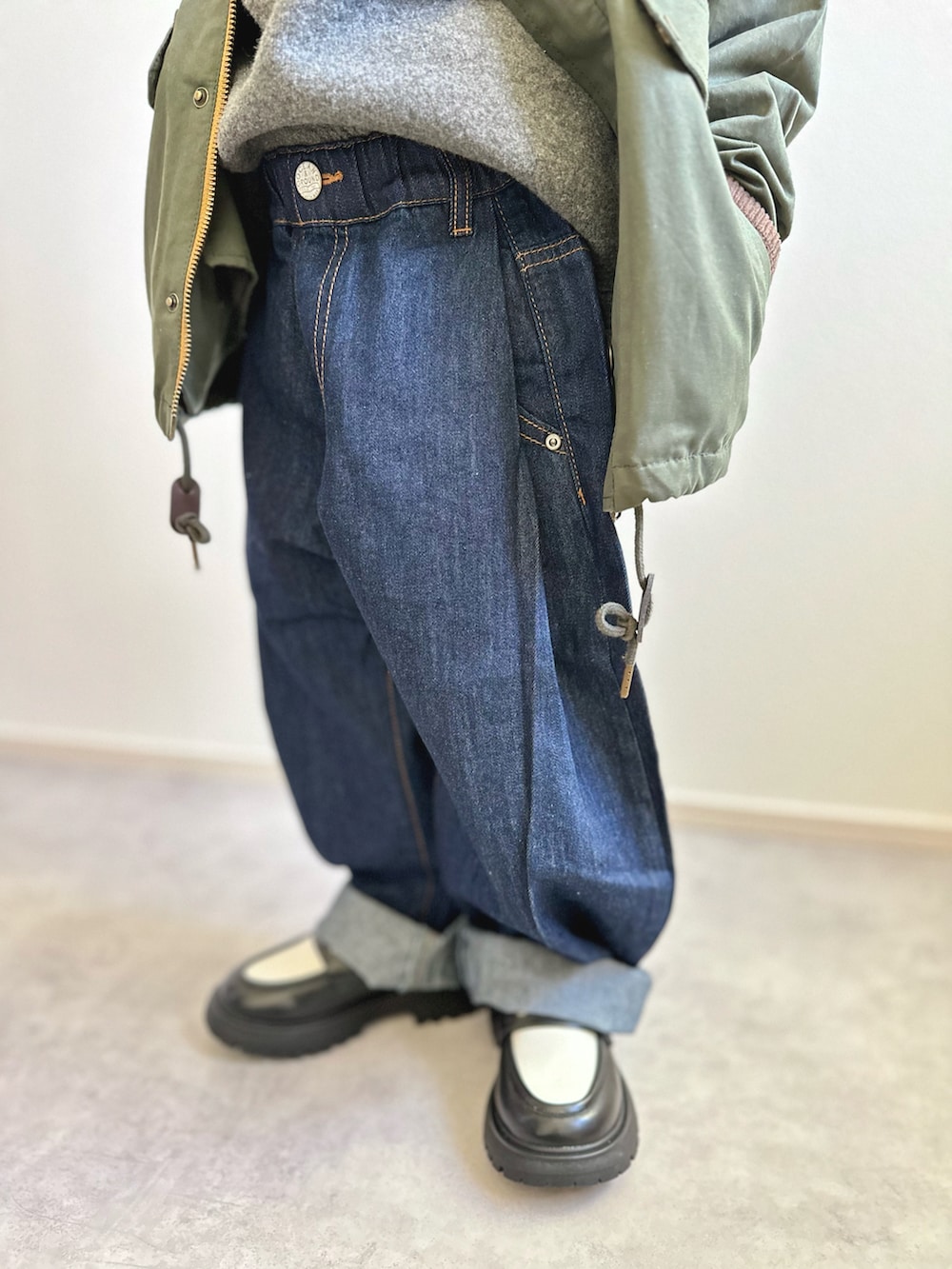 グリーン系のその他アウター、グレー系のニット/セーター、ホワイト系のTシャツ/カットソーを着用したキッズの冬コーディネートの3枚目の写真