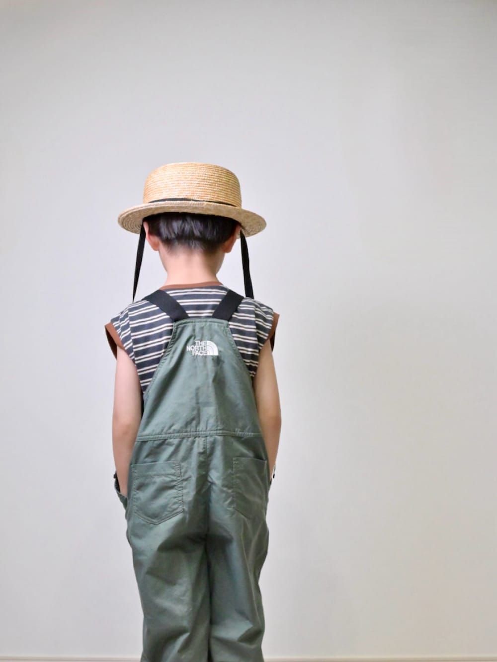 ブラック系のTシャツ/カットソー、ブラック系のスニーカー、グリーン系のその他ベビー用品を着用したキッズの春コーディネートの3枚目の写真