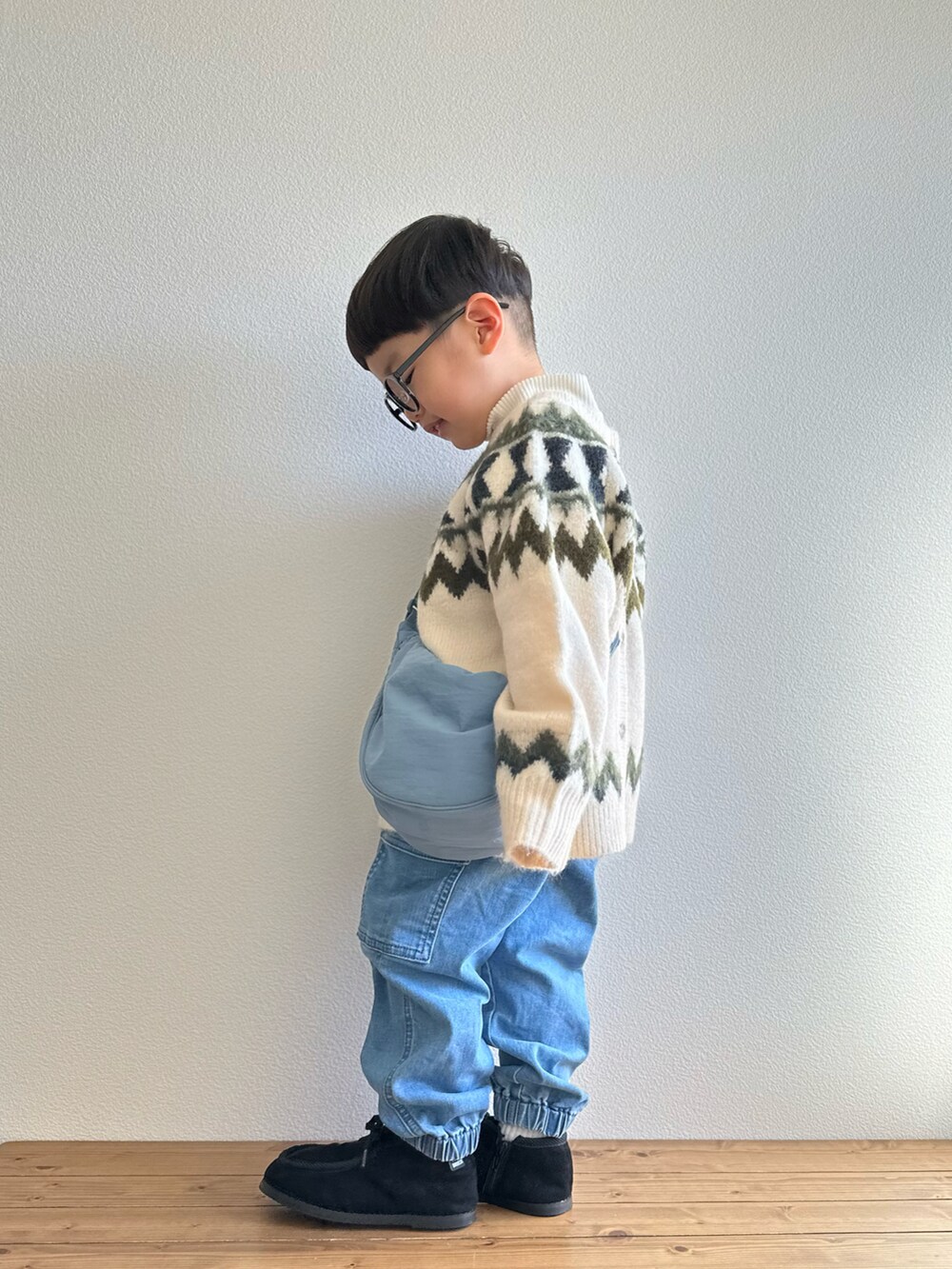 ホワイト系のカーディガン/ボレロ、ブルー系のカーゴパンツ、ホワイト系のTシャツ/カットソーを着用したキッズの冬コーディネートの4枚目の写真