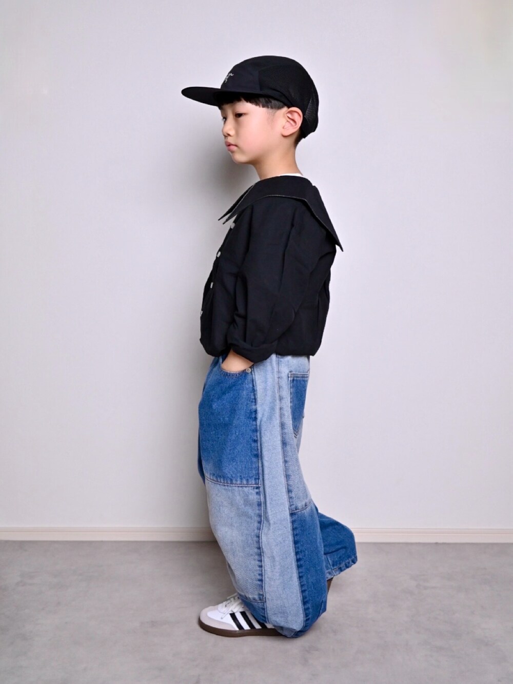 ブルー系のデニムパンツ、ブラック系のシャツ/ブラウス、ホワイト系のスニーカーを着用したキッズの春コーディネートの2枚目の写真