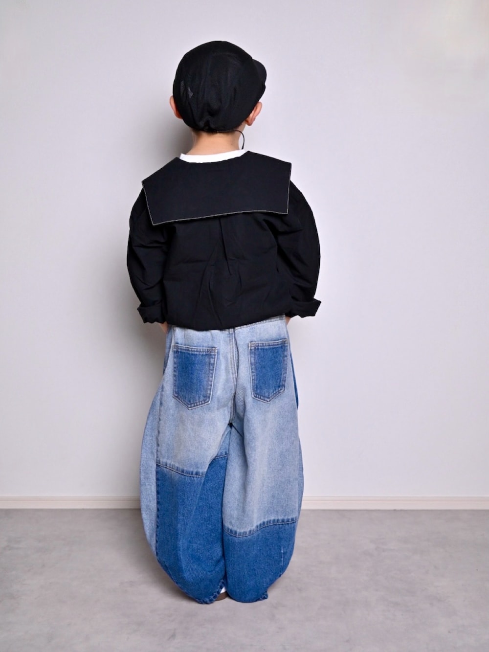 ブルー系のデニムパンツ、ブラック系のシャツ/ブラウス、ホワイト系のスニーカーを着用したキッズの春コーディネートの3枚目の写真