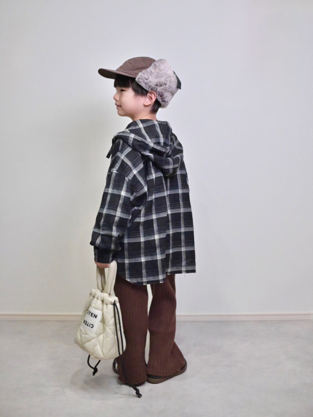 ベージュ系のニット/セーター、ブラック系のスニーカー、ブラック系のシャツ/ブラウスを着用したキッズの秋コーディネートの2枚目の写真