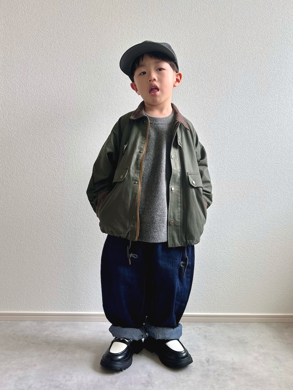 グリーン系のその他アウター、グレー系のニット/セーター、ホワイト系のTシャツ/カットソーを着用したキッズの冬コーディネートの4枚目の写真