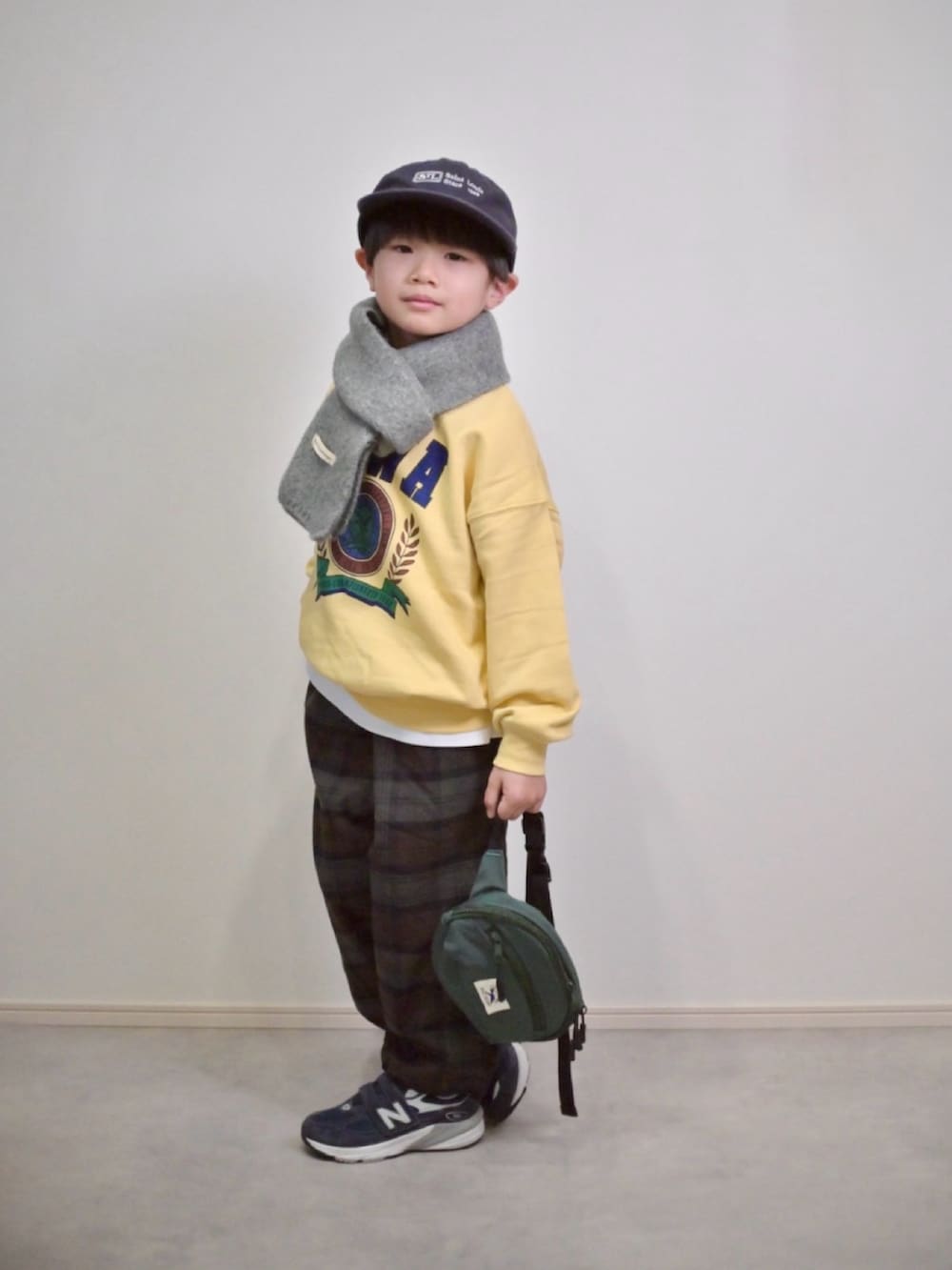 イエロー系のスウェット、グリーン系のその他パンツ、グリーン系のボディバッグ/ウエストポーチを着用したキッズの冬コーディネートの2枚目の写真