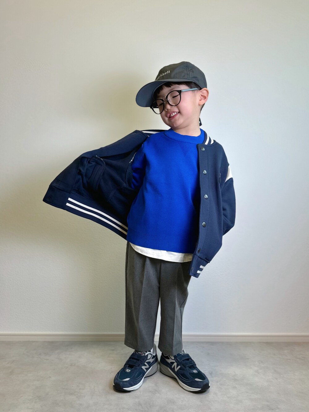 ブルー系のスタジャン、ブルー系のニット/セーター、ホワイト系のTシャツ/カットソーを着用したキッズの冬コーディネートの2枚目の写真