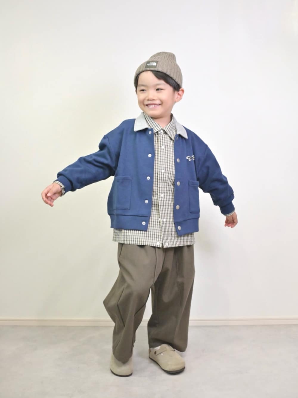 ブルー系のカーディガン/ボレロ、ホワイト系のシャツ/ブラウス、ブラウン系のスラックスを着用したキッズの秋コーディネートの4枚目の写真