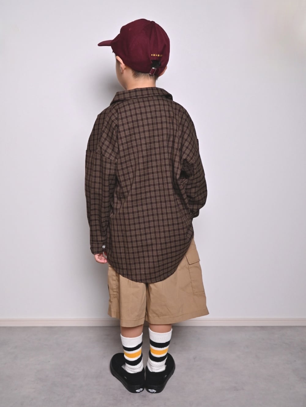 ブラック系のTシャツ/カットソー、ブラウン系のシャツ/ブラウス、ブラック系のローファーを着用したキッズの秋コーディネートの3枚目の写真