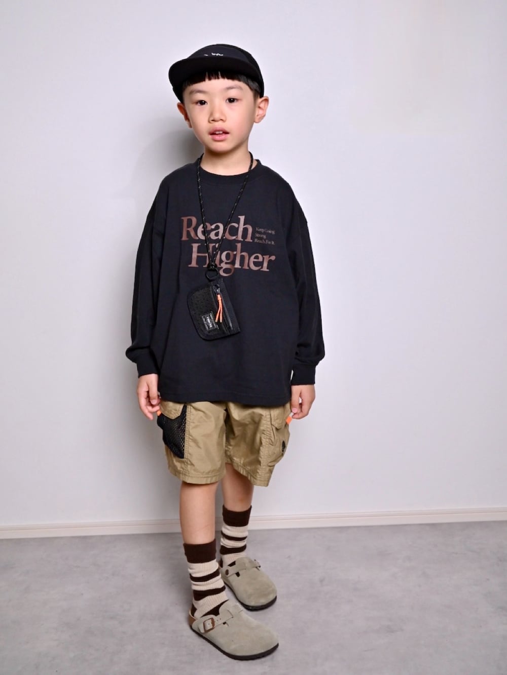 ブラック系のTシャツ/カットソー、ベージュ系のサンダル、グリーン系のその他パンツを着用したキッズの秋コーディネートの4枚目の写真
