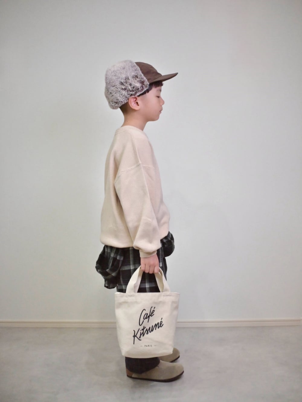 ベージュ系のニット/セーター、ブラック系のシャツ/ブラウス、グレー系のチノパンツを着用したキッズの秋コーディネートの2枚目の写真