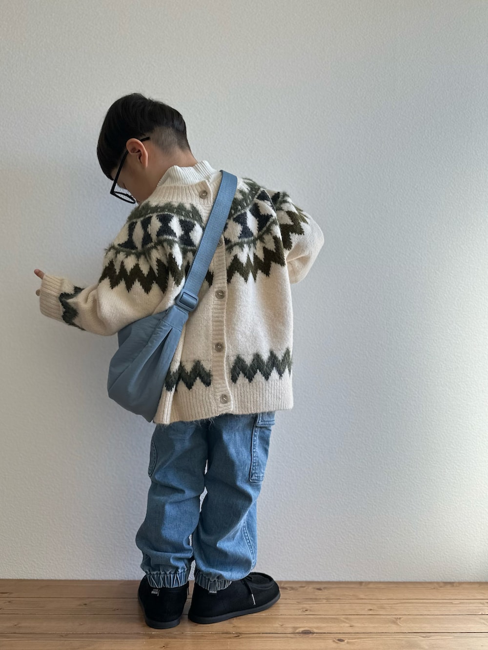 ホワイト系のカーディガン/ボレロ、ブルー系のカーゴパンツ、ホワイト系のTシャツ/カットソーを着用したキッズの冬コーディネートの3枚目の写真