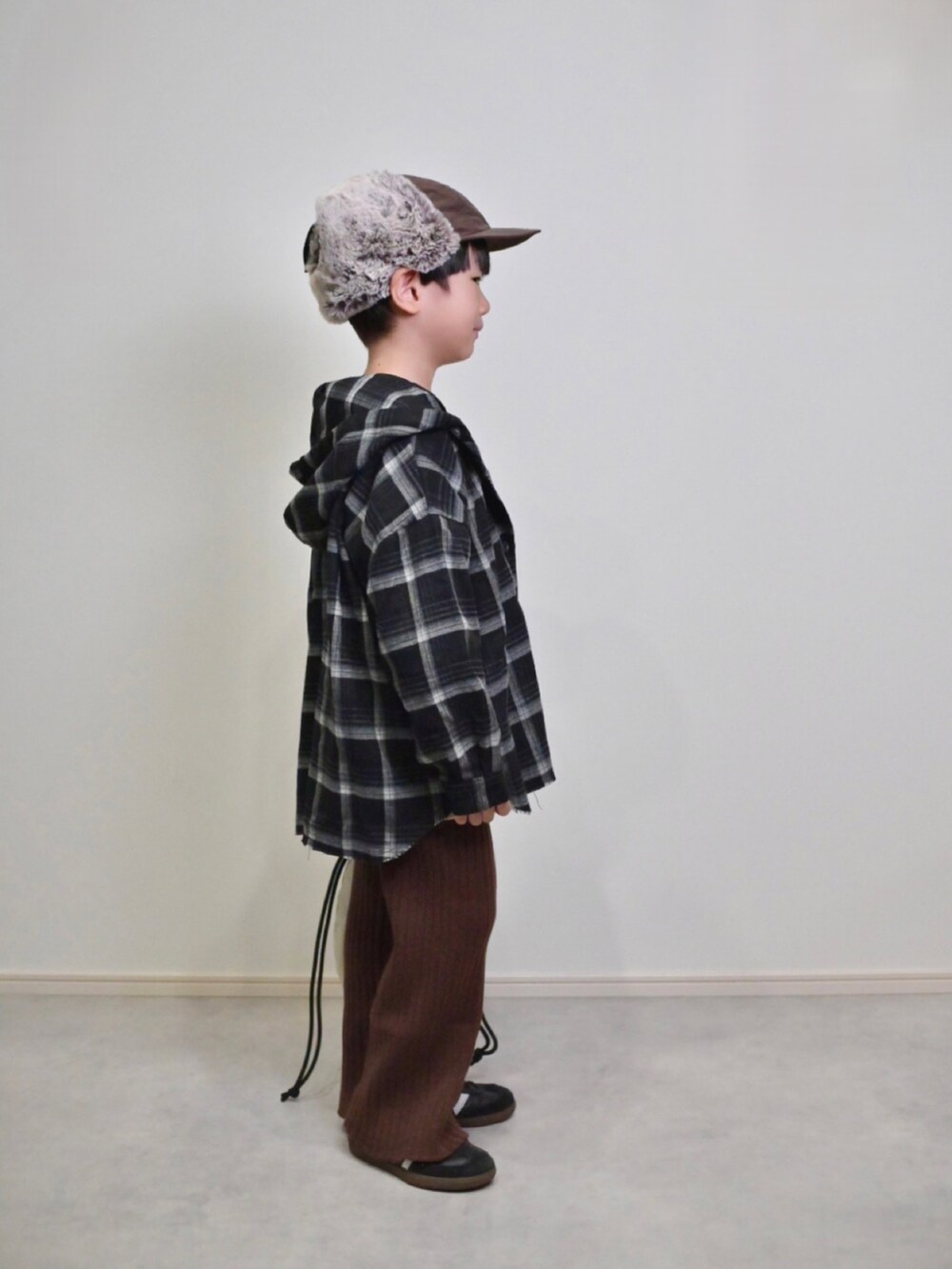 ベージュ系のニット/セーター、ブラック系のスニーカー、ブラック系のシャツ/ブラウスを着用したキッズの秋コーディネートの3枚目の写真