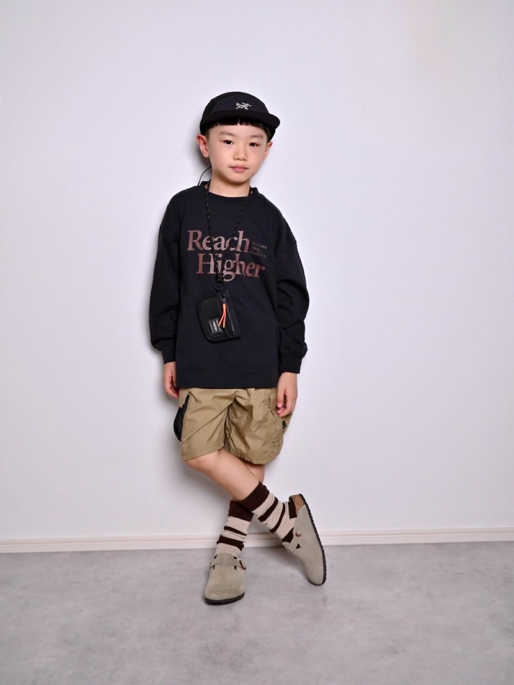 ブラック系のTシャツ/カットソー、ベージュ系のサンダル、グリーン系のその他パンツを着用したキッズの秋コーディネートの5枚目の写真
