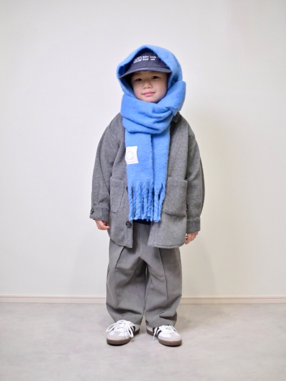 ブルー系のニット/セーター、グレー系のスラックス、ホワイト系のスニーカーを着用したキッズの冬コーディネートの4枚目の写真