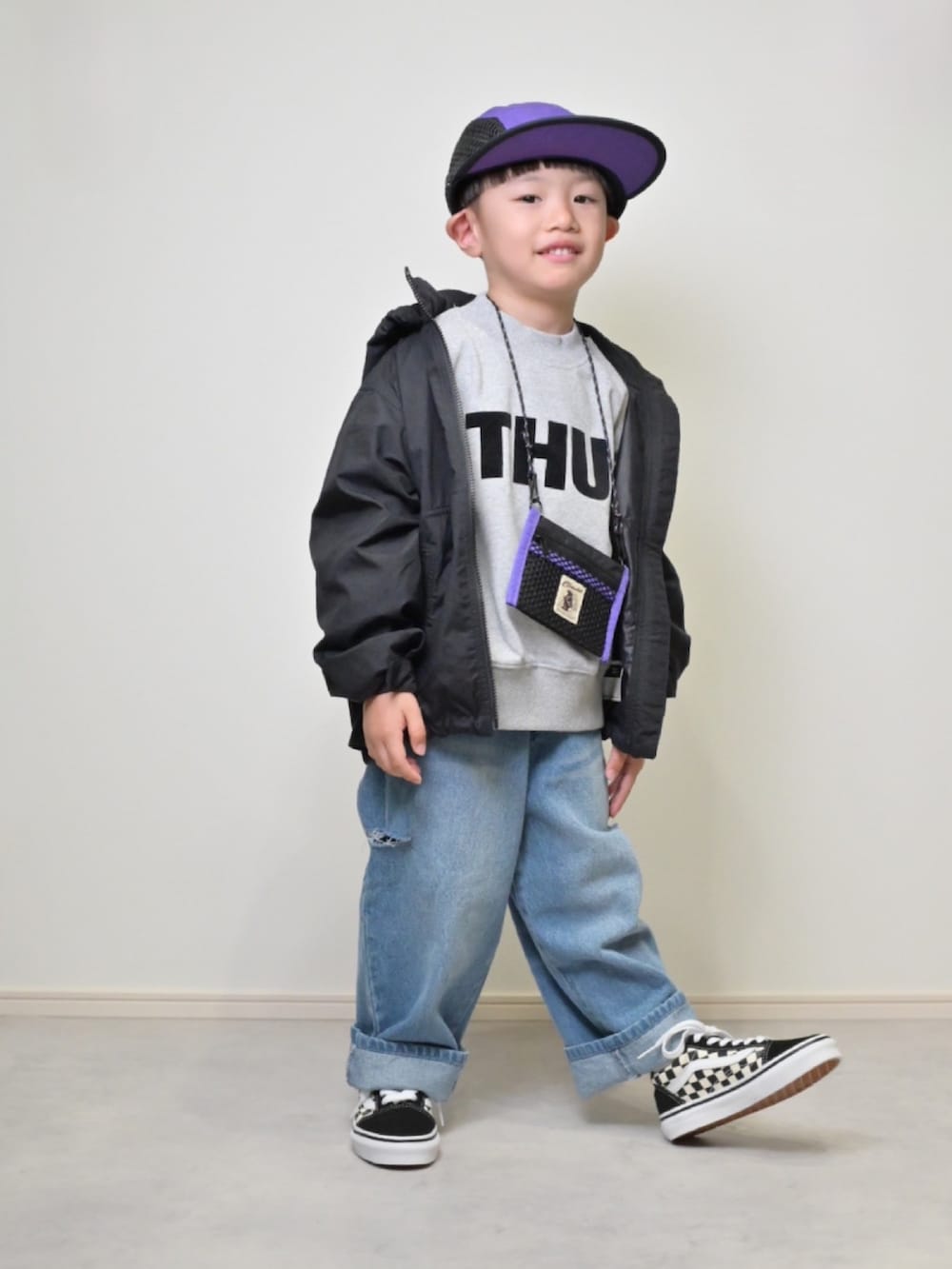 ブラック系のマウンテンパーカー、グレー系のスウェット、ブルー系のデニムパンツを着用したキッズの秋コーディネートの3枚目の写真