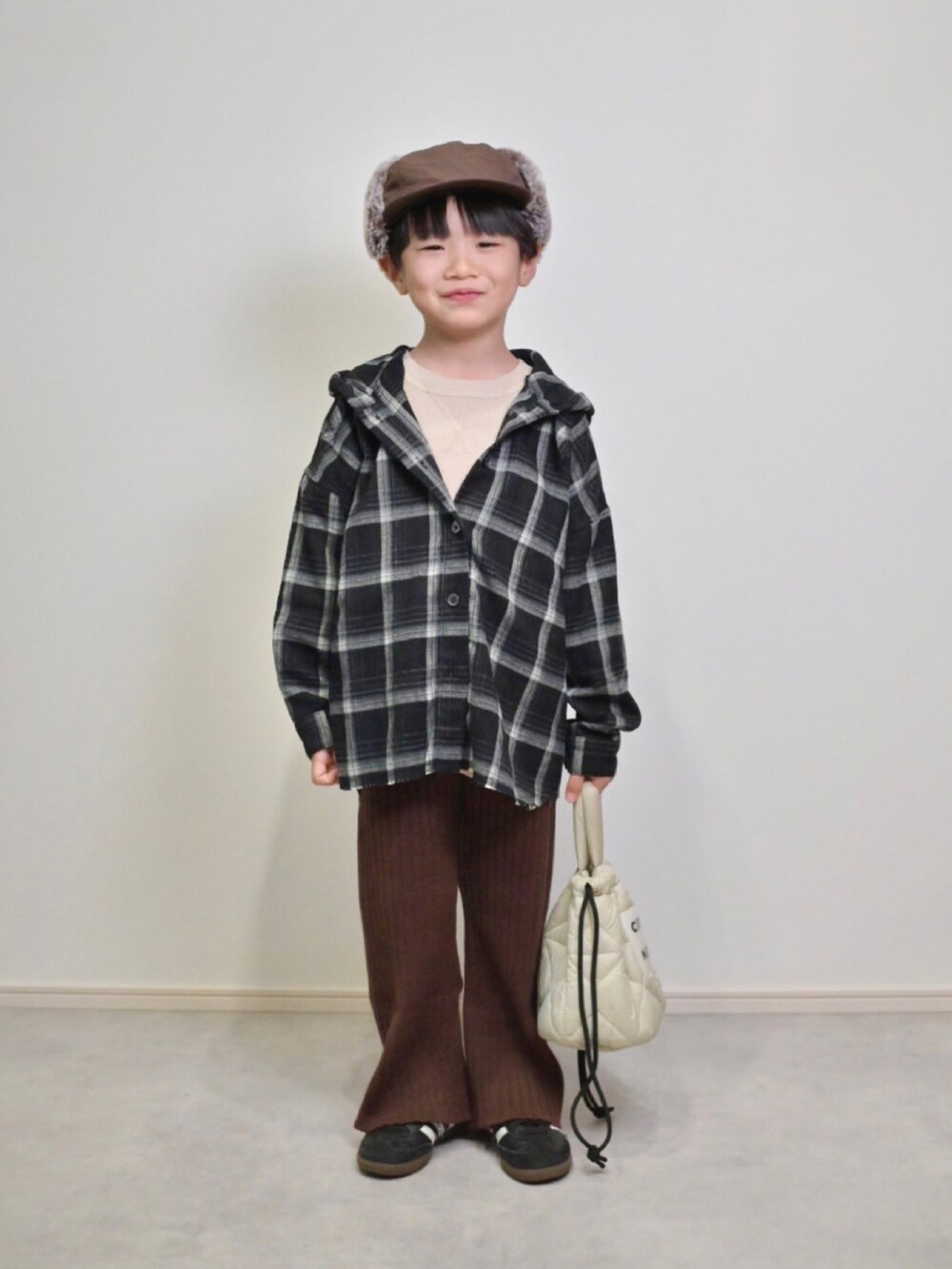 ベージュ系のニット/セーター、ブラック系のスニーカー、ブラック系のシャツ/ブラウスを着用したキッズの秋コーディネートの5枚目の写真