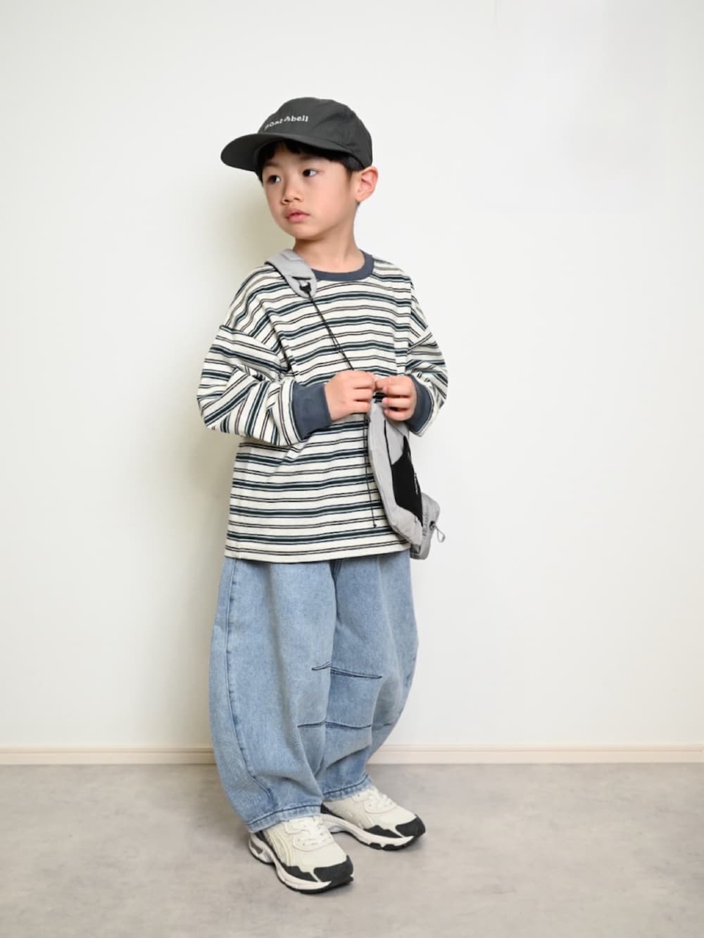 グレー系のTシャツ/カットソー、ブルー系のデニムパンツ、ブラック系のショルダーバッグを着用したキッズの冬コーディネートの3枚目の写真