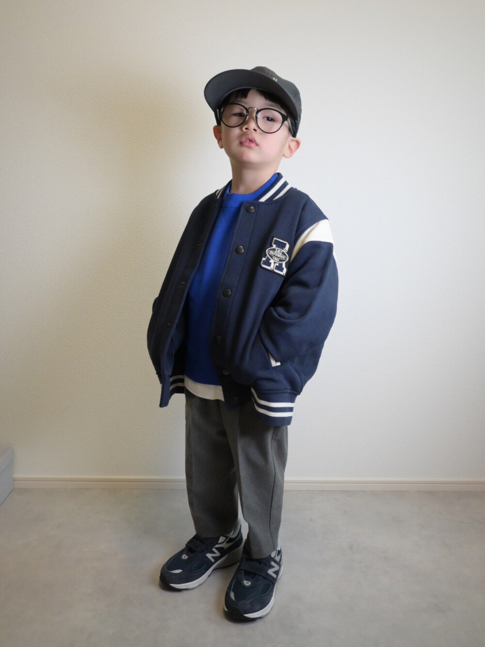ブルー系のスタジャン、ブルー系のニット/セーター、ホワイト系のTシャツ/カットソーを着用したキッズの冬コーディネートの3枚目の写真