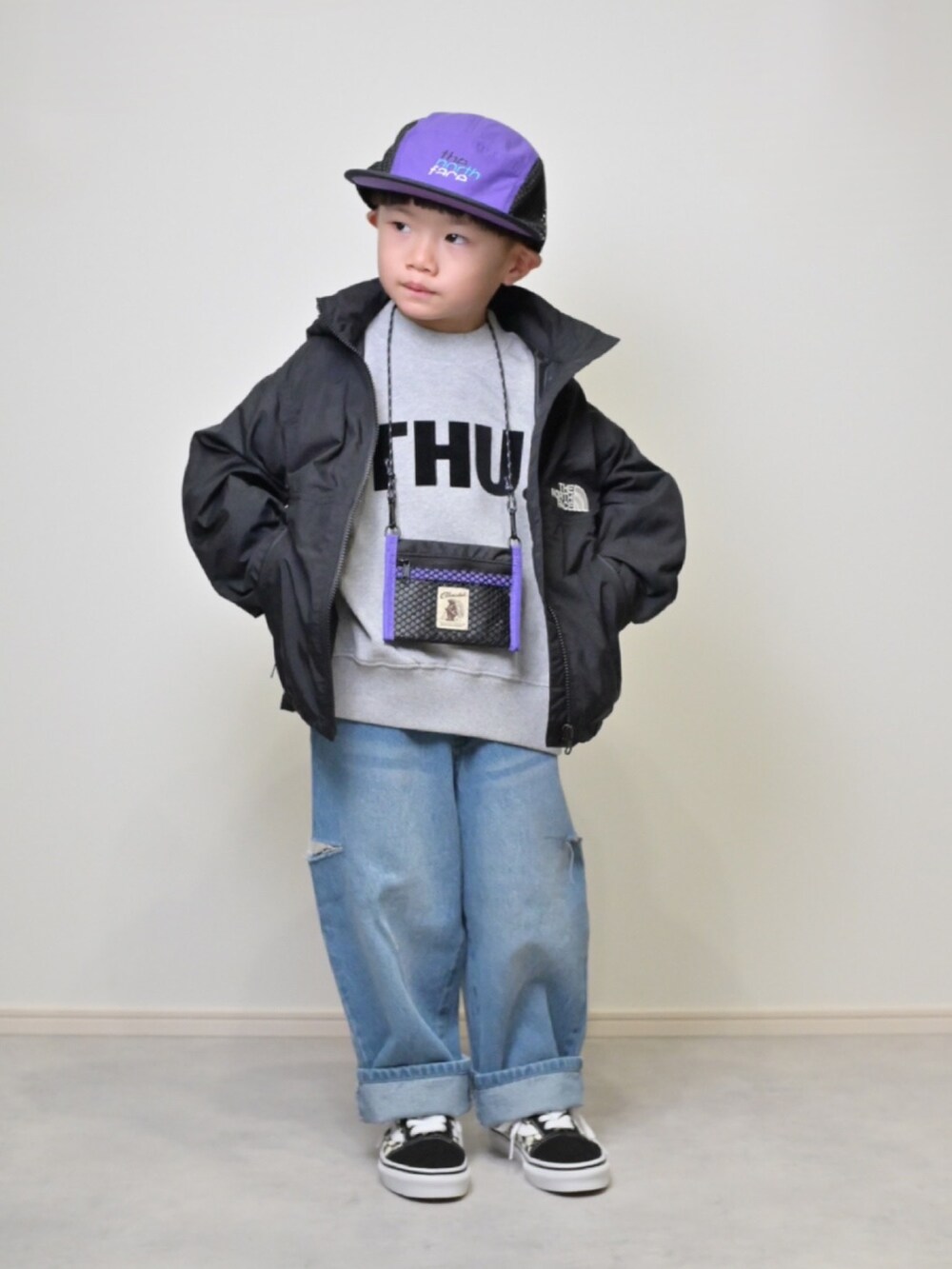 ブラック系のマウンテンパーカー、グレー系のスウェット、ブルー系のデニムパンツを着用したキッズの秋コーディネートの2枚目の写真