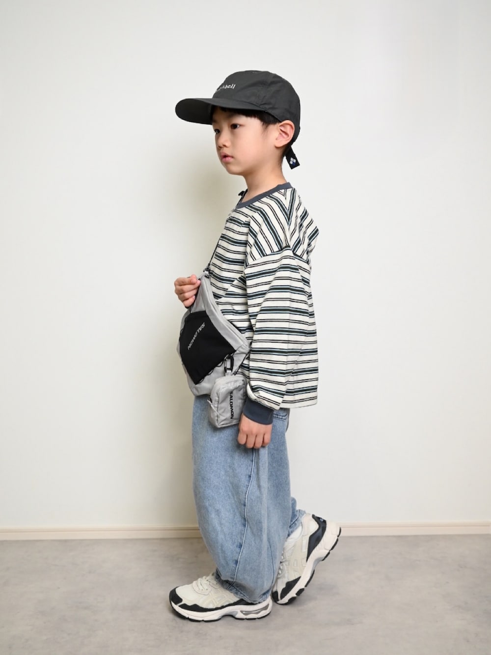 グレー系のTシャツ/カットソー、ブルー系のデニムパンツ、ブラック系のショルダーバッグを着用したキッズの冬コーディネートの4枚目の写真