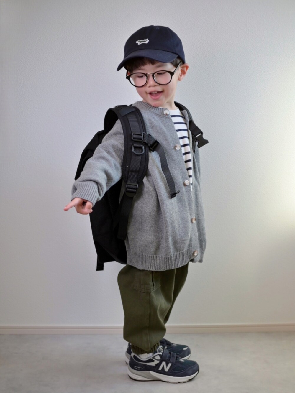 グレー系のカーディガン/ボレロ、ホワイト系のTシャツ/カットソー、グリーン系のカーゴパンツを着用したキッズの冬コーディネートの4枚目の写真