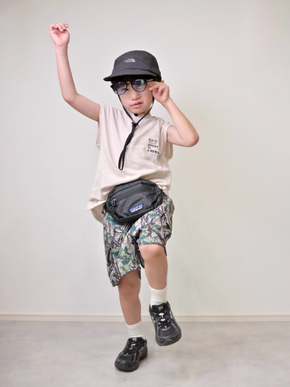 ベージュ系のカーゴパンツ、ホワイト系のTシャツ/カットソー、ブラック系のボディバッグ/ウエストポーチを着用したキッズの夏コーディネートの4枚目の写真