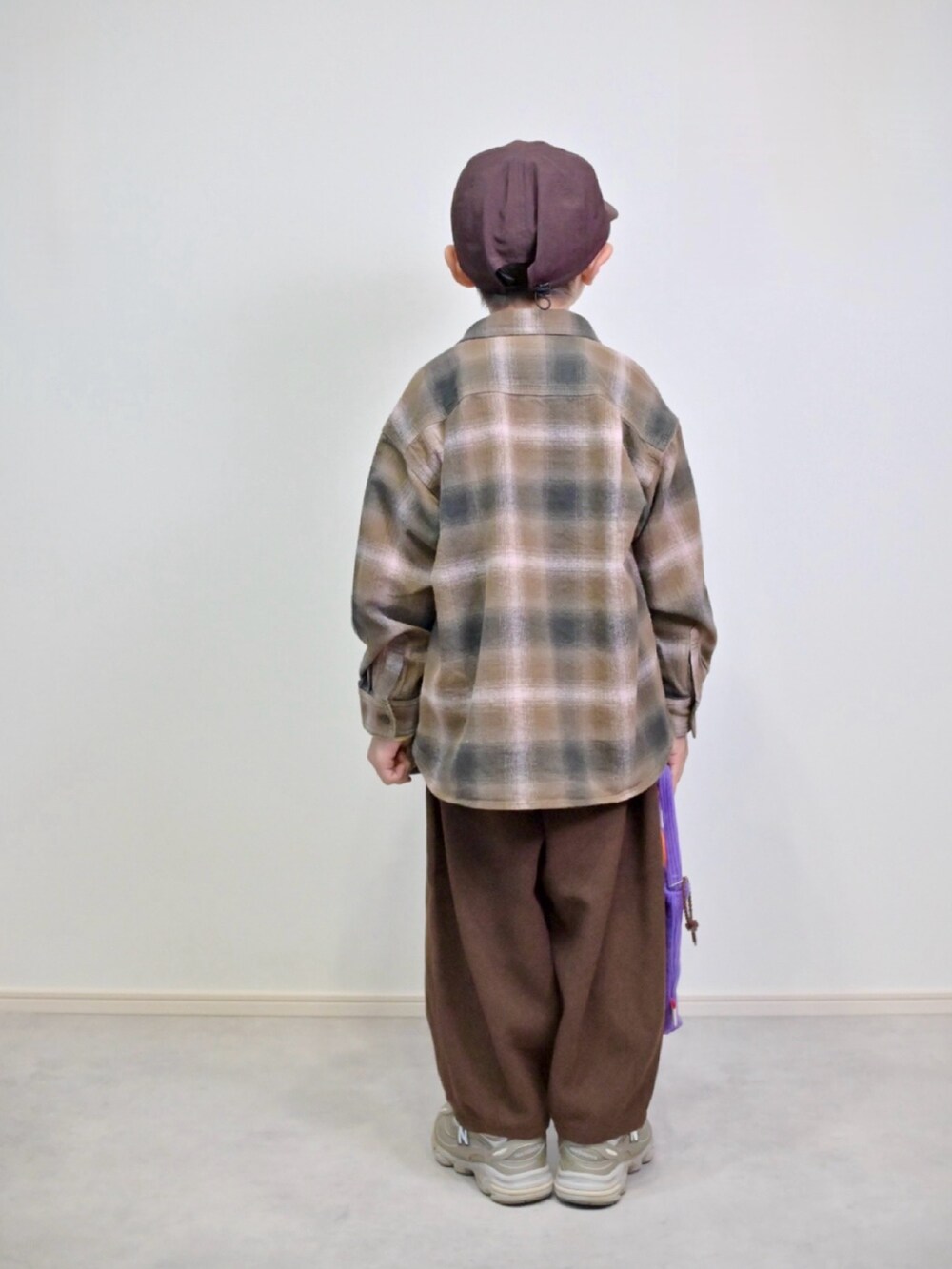 ブラウン系のシャツ/ブラウス、ベージュ系のスニーカー、イエロー系のTシャツ/カットソーを着用したキッズの冬コーディネートの3枚目の写真