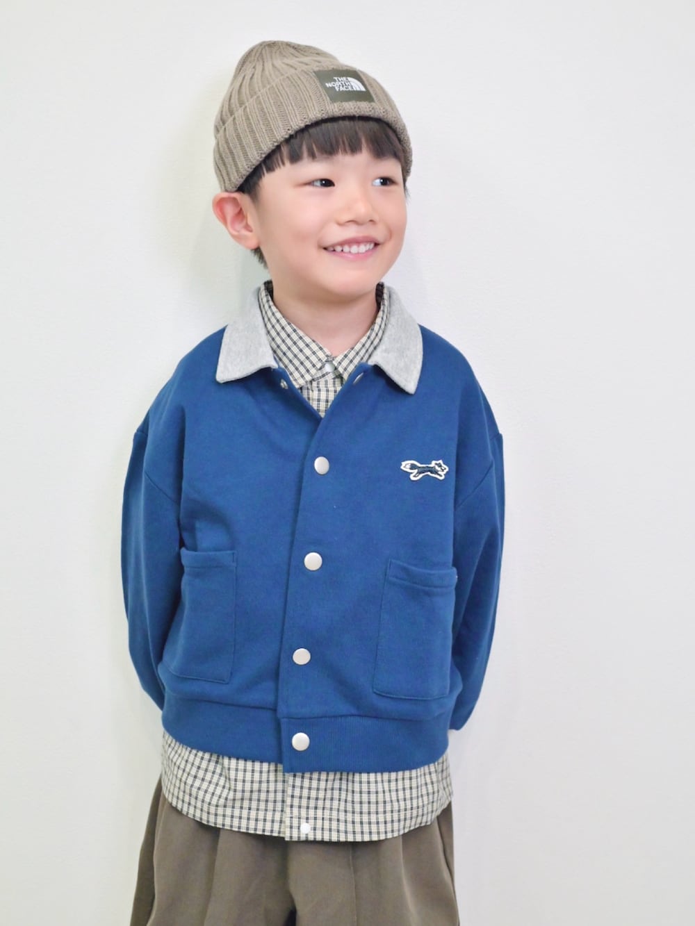 ブルー系のカーディガン/ボレロ、ホワイト系のシャツ/ブラウス、ブラウン系のスラックスを着用したキッズの秋コーディネートの5枚目の写真