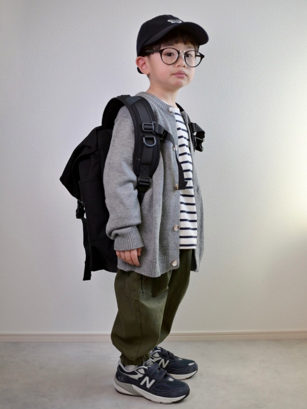 グレー系のカーディガン/ボレロ、ホワイト系のTシャツ/カットソー、グリーン系のカーゴパンツを着用したキッズの冬コーディネートの3枚目の写真