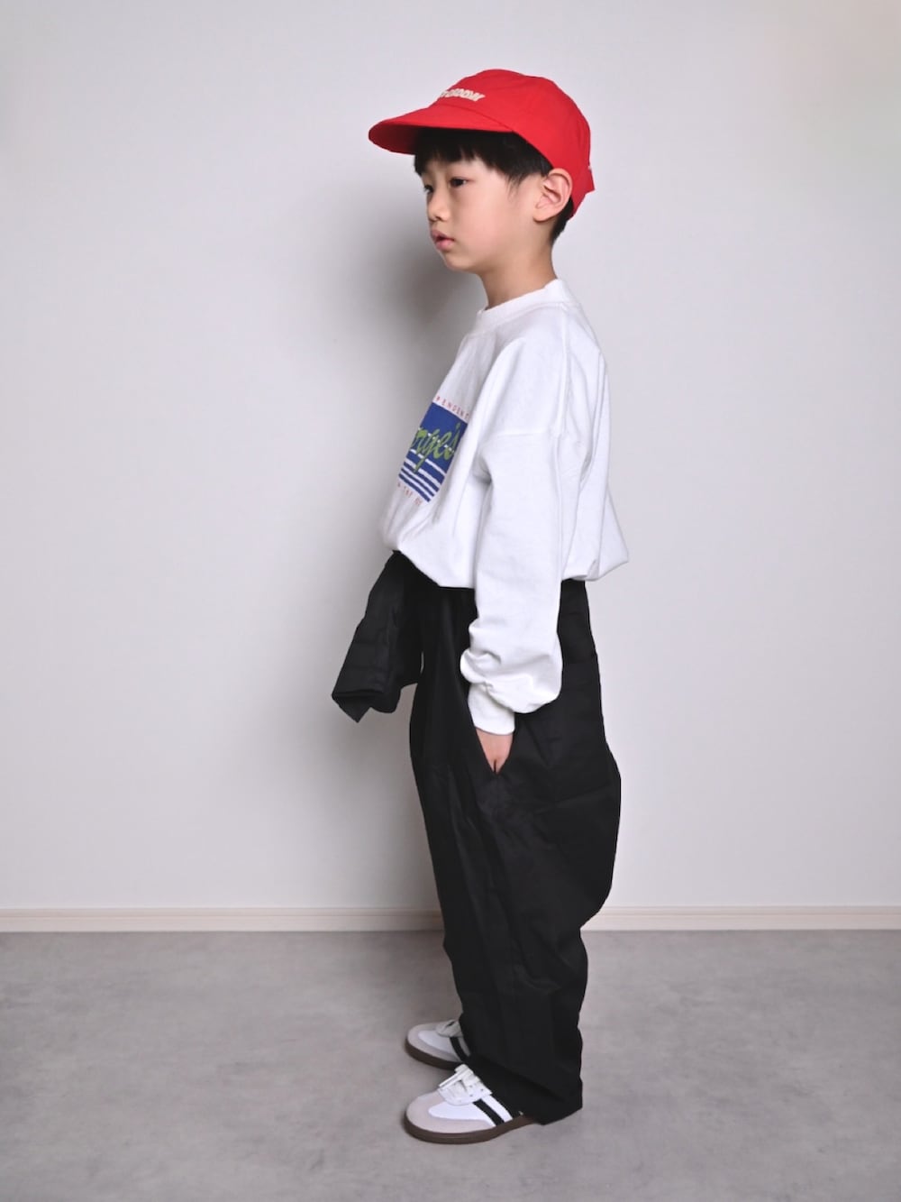 ホワイト系のTシャツ/カットソー、ブラック系のつなぎ/オールインワン、ホワイト系のスニーカーを着用したキッズの春コーディネートの2枚目の写真