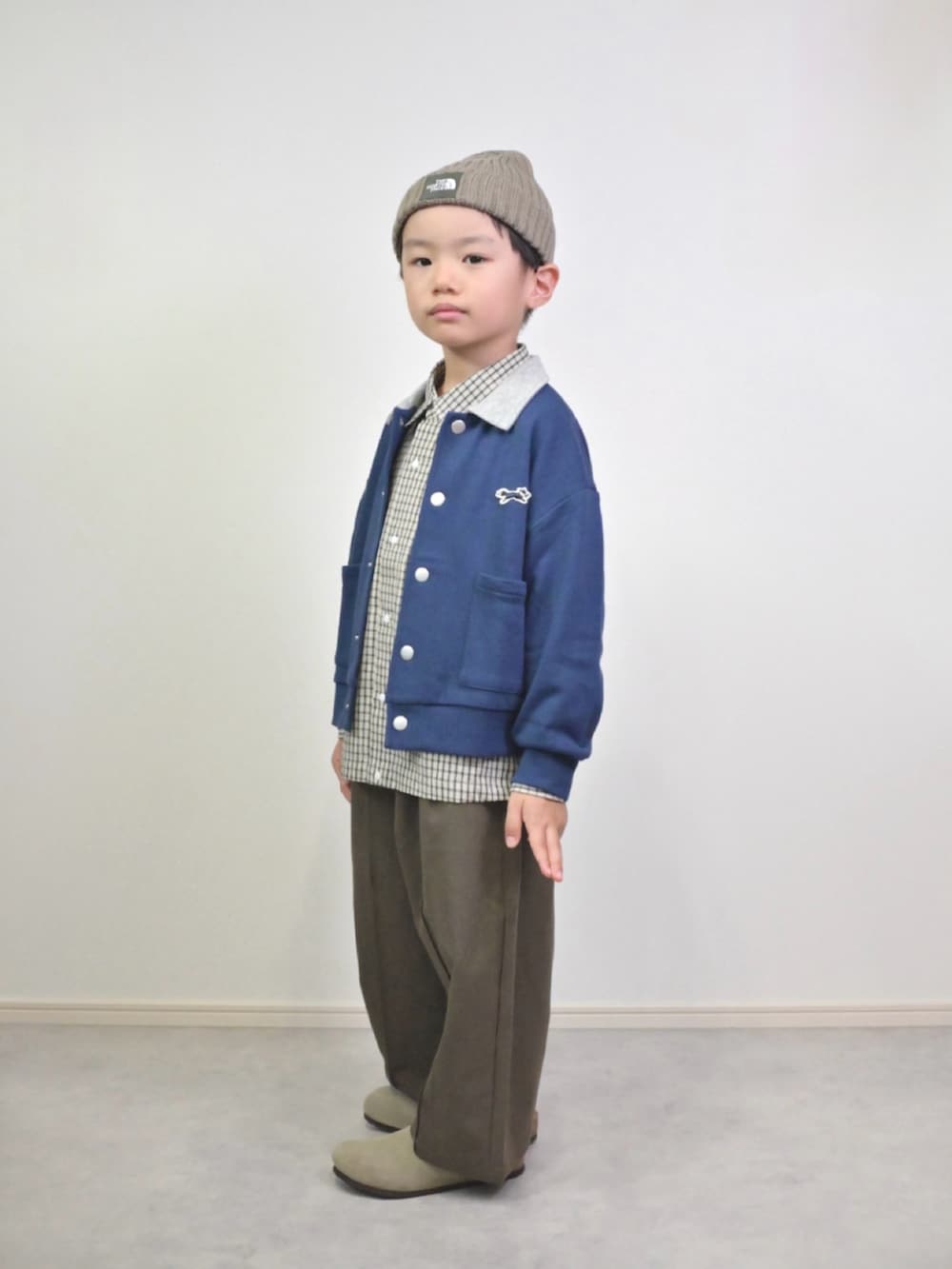 ブルー系のカーディガン/ボレロ、ホワイト系のシャツ/ブラウス、ブラウン系のスラックスを着用したキッズの秋コーディネートの3枚目の写真