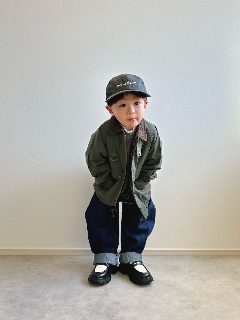 グリーン系のその他アウター、グレー系のニット/セーター、ホワイト系のTシャツ/カットソーを着用したキッズの冬コーディネートの2枚目の写真