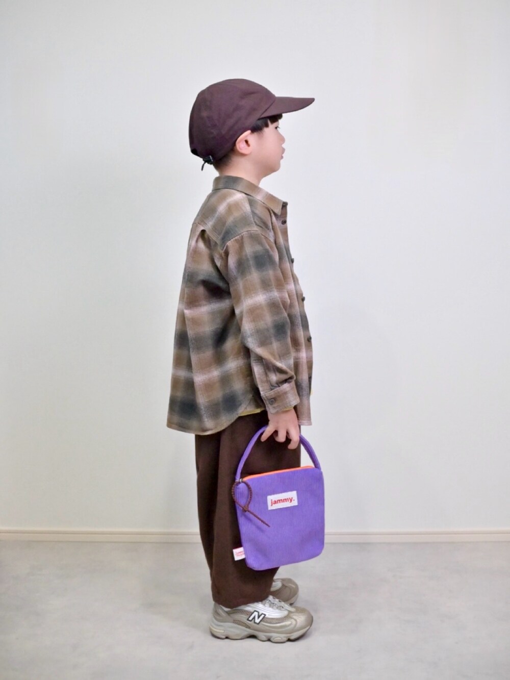 ブラウン系のシャツ/ブラウス、ベージュ系のスニーカー、イエロー系のTシャツ/カットソーを着用したキッズの冬コーディネートの2枚目の写真