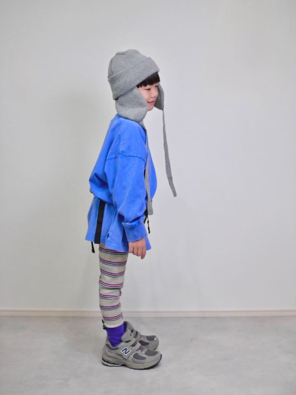 ブルー系のTシャツ/カットソー、グリーン系のボディバッグ/ウエストポーチ、グレー系のスニーカーを着用したキッズの秋コーディネートの2枚目の写真