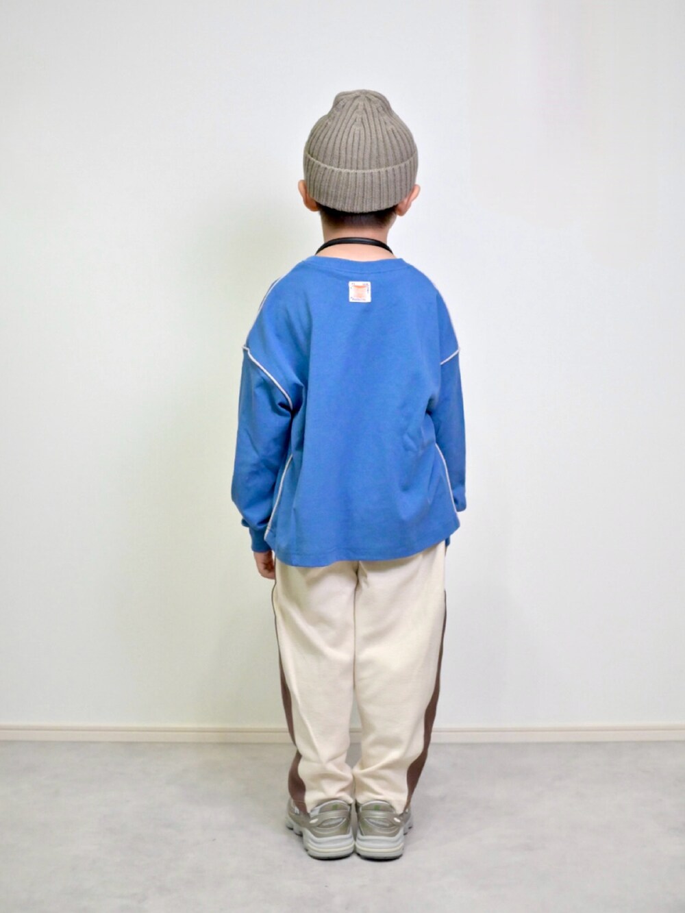 ブルー系のTシャツ/カットソー、ベージュ系のその他パンツ、ベージュ系のスニーカーを着用したキッズの秋コーディネートの4枚目の写真