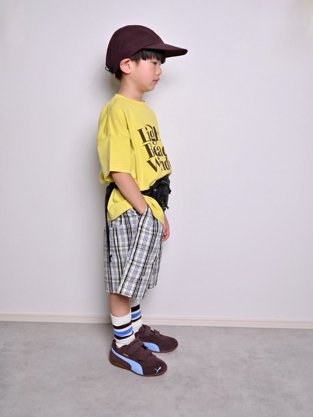 イエロー系のTシャツ/カットソー、ホワイト系のチノパンツ、ブラウン系のスニーカーを着用したキッズの春コーディネートの2枚目の写真