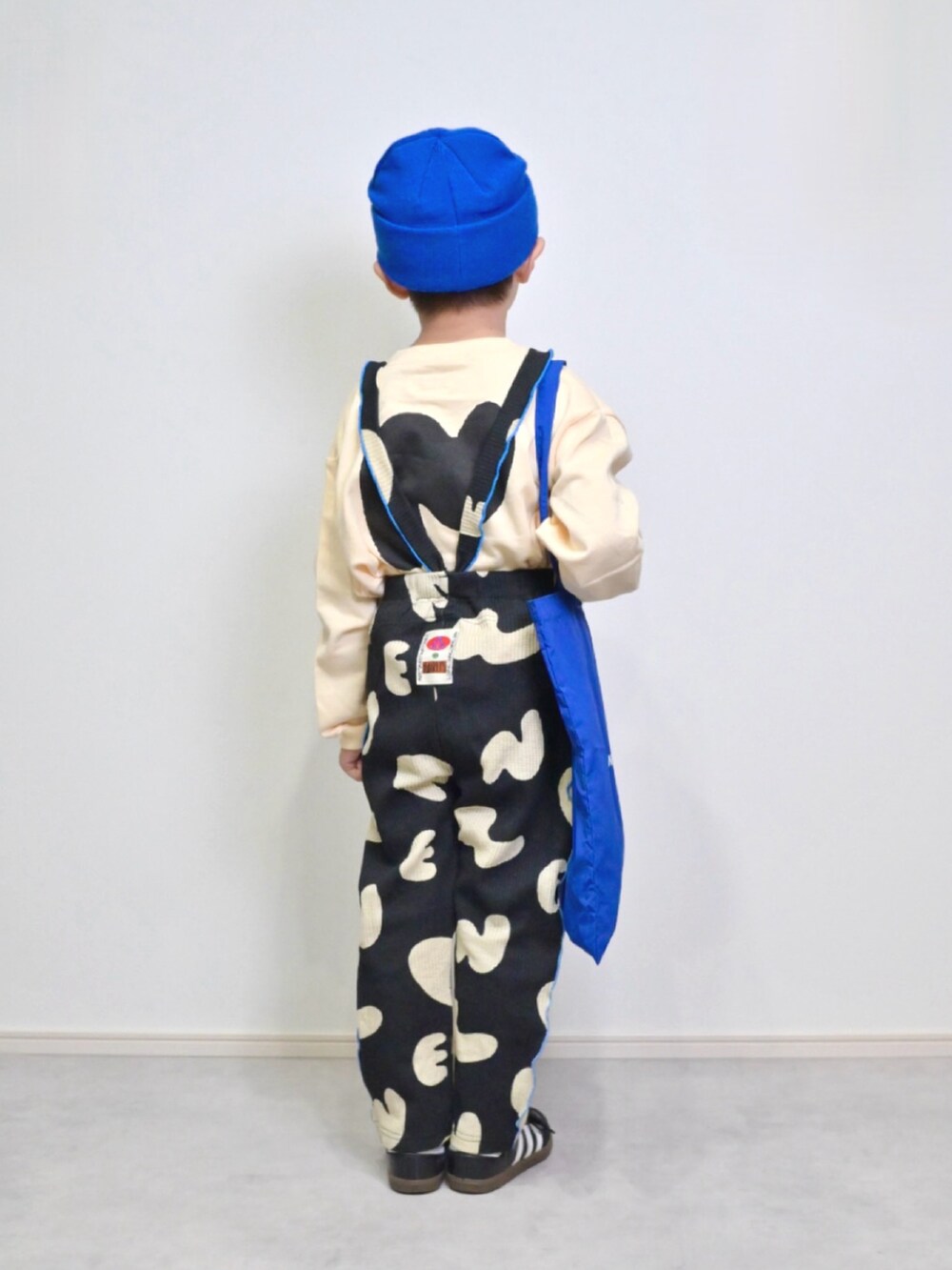 ブルー系のトートバッグ、ブラック系のスニーカー、ホワイト系のスウェットを着用したキッズの秋コーディネートの3枚目の写真