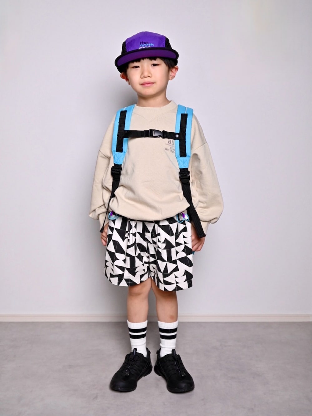 ブラック系のスニーカー、ベージュ系のスウェット、ブラック系のその他パンツを着用したキッズの春コーディネートの3枚目の写真