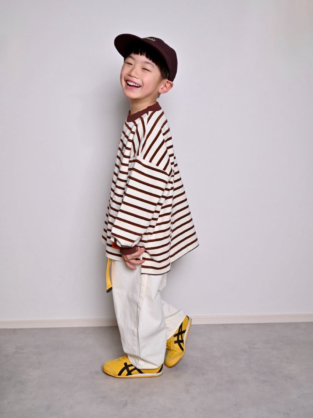 ホワイト系のTシャツ/カットソー、イエロー系のスニーカー、イエロー系のベルトを着用したキッズの春コーディネートの4枚目の写真