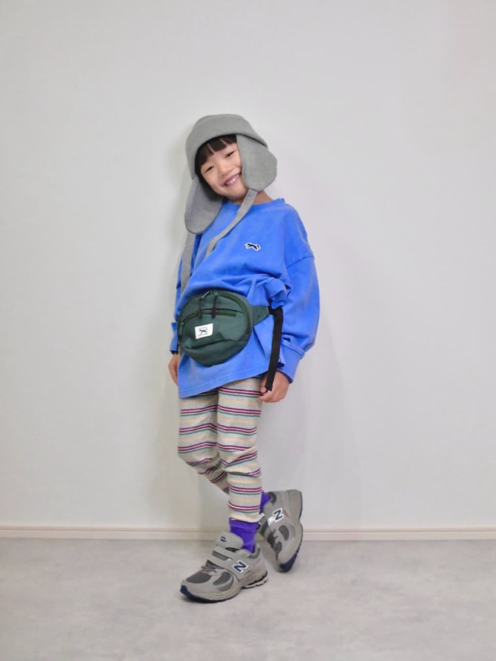 ブルー系のTシャツ/カットソー、グリーン系のボディバッグ/ウエストポーチ、グレー系のスニーカーを着用したキッズの秋コーディネートの4枚目の写真