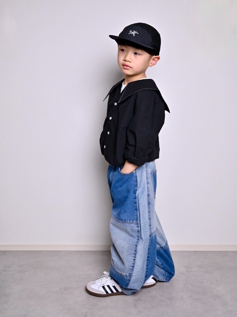 ブルー系のデニムパンツ、ブラック系のシャツ/ブラウス、ホワイト系のスニーカーを着用したキッズの春コーディネートの4枚目の写真