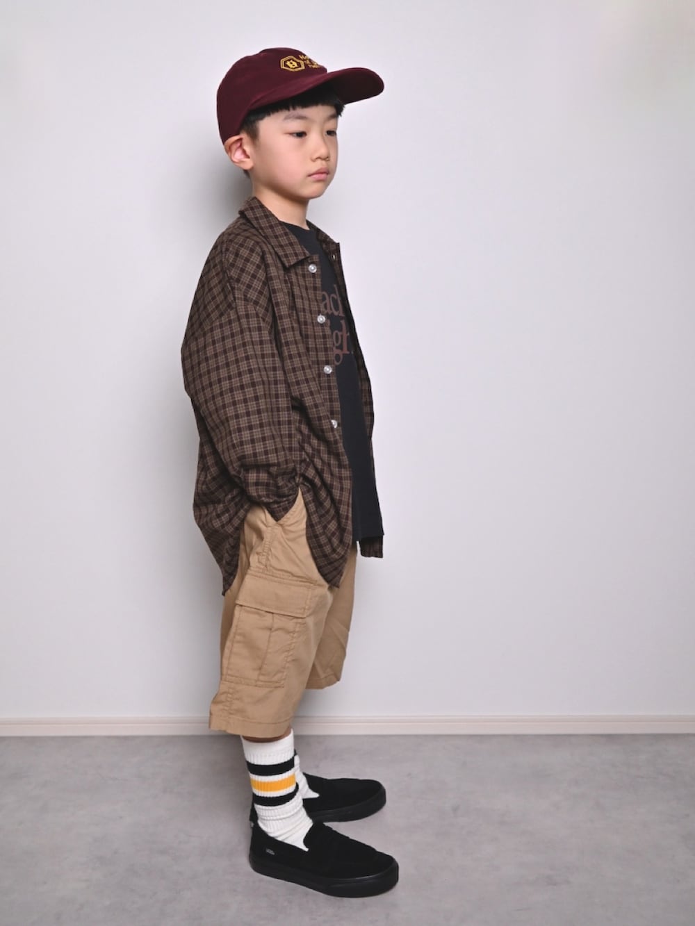 ブラック系のTシャツ/カットソー、ブラウン系のシャツ/ブラウス、ブラック系のローファーを着用したキッズの秋コーディネートの2枚目の写真