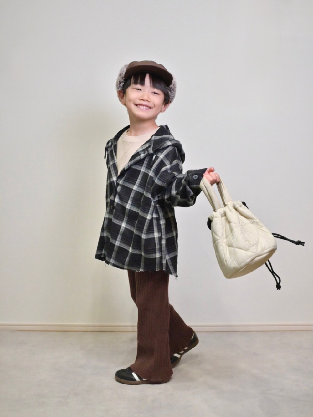 ベージュ系のニット/セーター、ブラック系のスニーカー、ブラック系のシャツ/ブラウスを着用したキッズの秋コーディネートの4枚目の写真