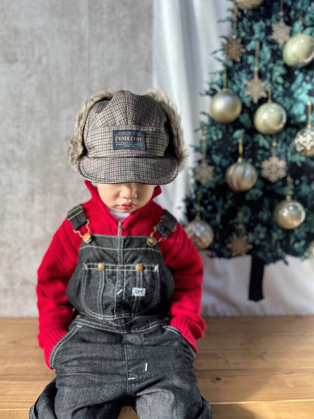 レッド系のニット/セーター、ホワイト系のトップス、ブルー系のサロペット/オーバーオールを着用したキッズの冬コーディネートの4枚目の写真